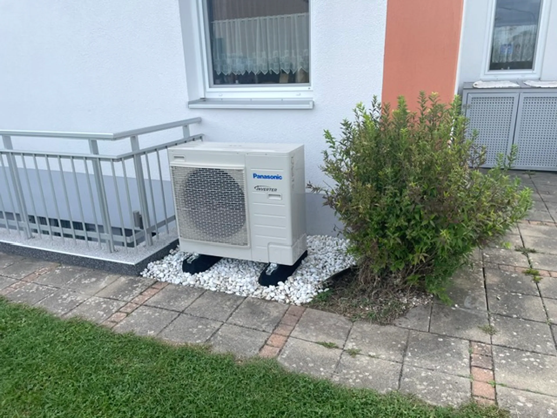 Kompakte Panasonic-Wärmepumpe an einer Hauswand